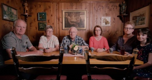 Familie sitzt zusammen am Tisch.
