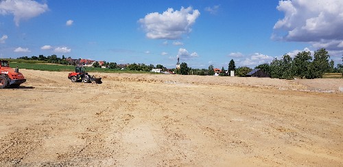 Blick von der Baustelle in Richtung Amrichshausen. Am Horizont sind Häuser und der Kirchturm zu sehen.