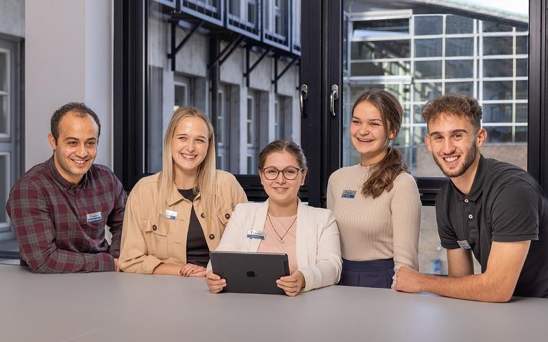 Junge Menschen sitzen zusammen an einem Tisch.