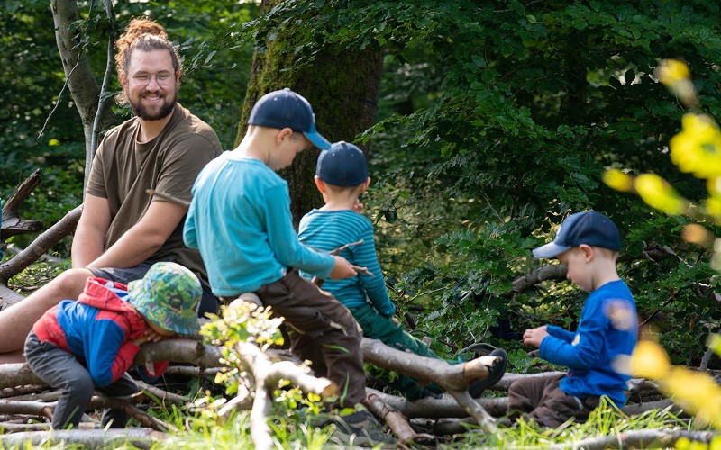 Auszubildender mit Kindern im Freien