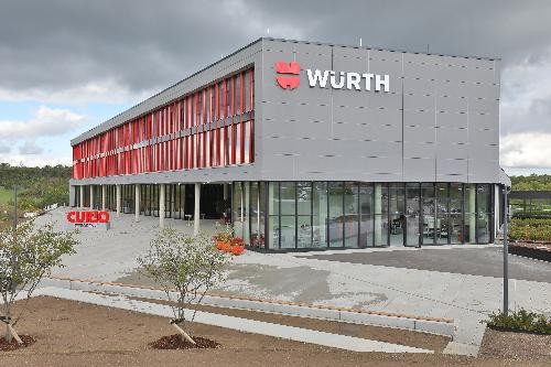 Außenansicht eines Gebäudes mit roten Fensternrahmen und dem Firmenlogo Würth
