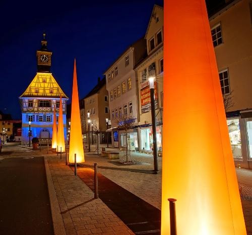 Altes Rathaus am Abend mit farbigen Leuchtaufstellern.