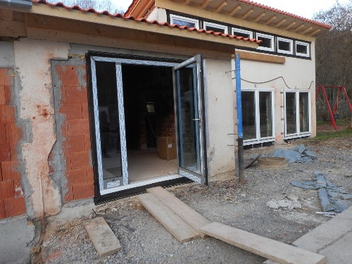 Blick auf eine offene Glastüre an dem Anbau an das bestehende Kindergartengebäude