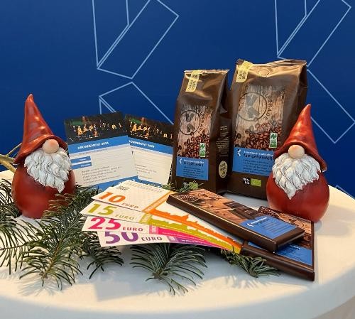 2 Kulturabonnement-Karten, 1 Tafel Schokolade, 2 Packungen Kaffee, Einkaufsgutscheine, umrahmt von zwei roten Weihnachtsmannfiguren