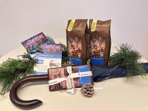 Zu sehen ein Regenschirm, liegend. Schokolade und Kaffe. Geschmückt mit Tannenzweifen.