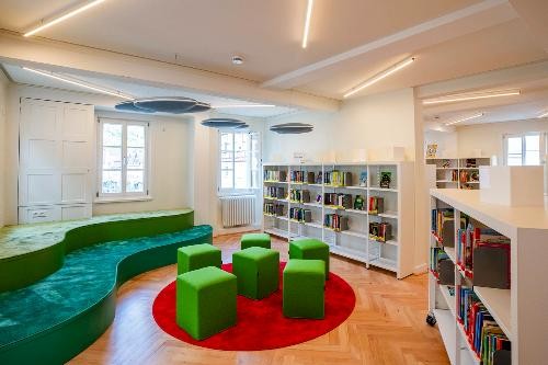 Die Bibliothek von innen mit Bücherregalen und Sitzmöglichkeiten.