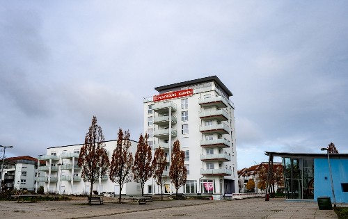 vorne im Bild Platz im Stadtteil Taläcker, im Hintergrund das hohe Gebäude auf dem Claude-Monet-latz