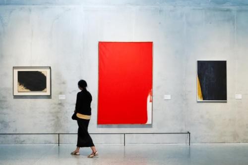 Foto: Ausstellungseinblick mit Arbeiten von Arnulf Rainer © Arnulf Rainer; Foto: Würth / Ufuk Arslan Eine Frau schaut sich die Kunstwerke von Arnulf Rainer im Museum Würth 2 in Künzelsau an.