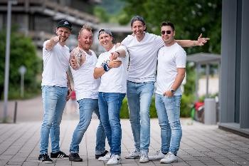 fünf Herren in weißen T-Shirts und Jeans