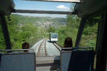 Zwei Menschen fahren in der Bergbahn Richtung Tal.