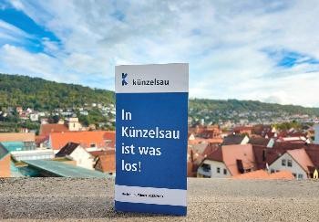 Blaue Broschüre mit Künzelsau im Hintergrund.