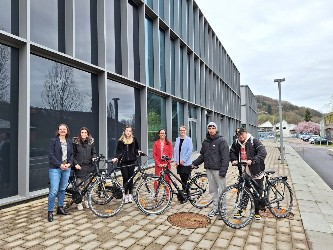 Menschen mit vier Fahrrädern an der Hochschule Künzelsau.
