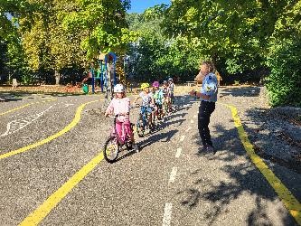 Kinder auf Fahrrädern mit einem Polizeibeamten.