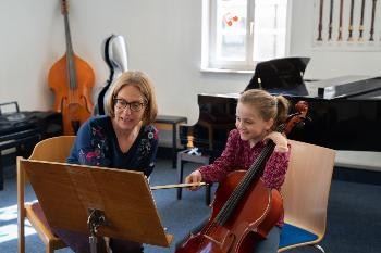 Lehrerin und Schülerin mit Cello