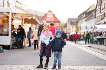 Zwei Kinder in der Bildmitte auf dem Marktgelände in der Hauptstraße