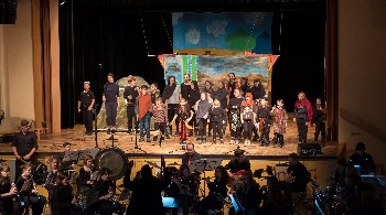 Kinder mit Instrumenten auf der Bühne mit Publikum im Vordergrund