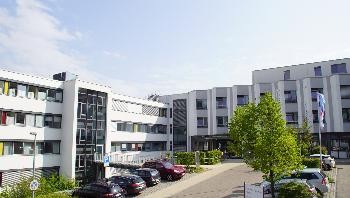 links im Bild das Gebäude MediKÜN, rechts das Gebäude des ehemaligen Krankenhauses