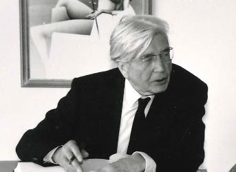 Hermann Lenz im dunklen Jacket mit Stift in der recht Hand beim Eintrag ins Goldene Buche