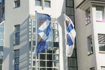 Zwei wehende Flaggen vor dem Rathaus.