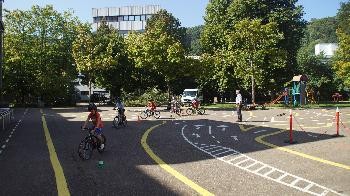 Kinder fahren auf dem Pausenhof Fahrrad.