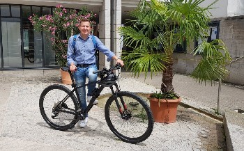 Stefan Neumann steht neben einem Fahrrad.