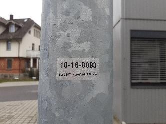 Schild auf dem Mast einer Straßenlaterne - mit Nummer und E-Mail-Adresse