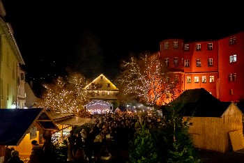 Schlossplatz mit Weihnachtsmarkthütten, stimmungsvoll beleuchtet, viele Menschen