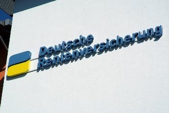 blau-gelbes Logo und blauer Schriftzug Deutsche Rentenversicherung an einer Wand