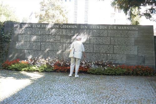 Eine Frau steht vor dem Kriegerdenkmal.