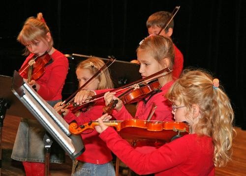 Fünf Schülerinnen und Schüler der Jugendmusikschule spielen Geige.