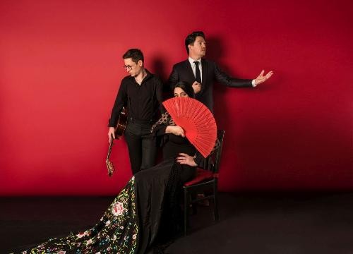 Zwei Gitarristen und eine Frau mit Fächer.