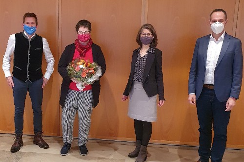 Reintraut Lindenmaier erhält einen Blumenstrauß, daneben Stefan Neumann, Sonja Naegelin und Christoph Spieles.