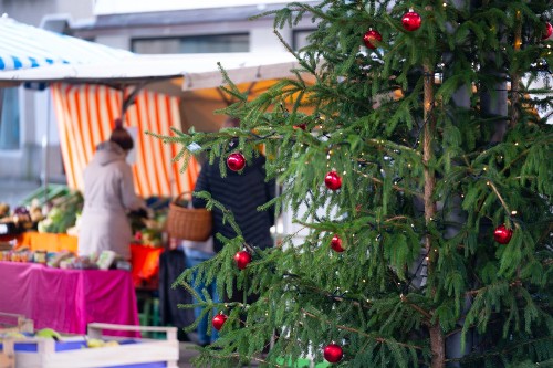 Ein geschmückter Weihnachtsbaum auf dem Wochenmarkt.
