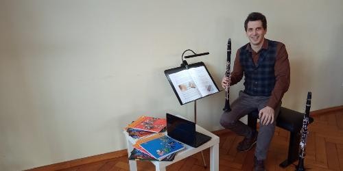 Evgeniy Guzahvin mit einer Klarinette in der Hand unterrichtet online.