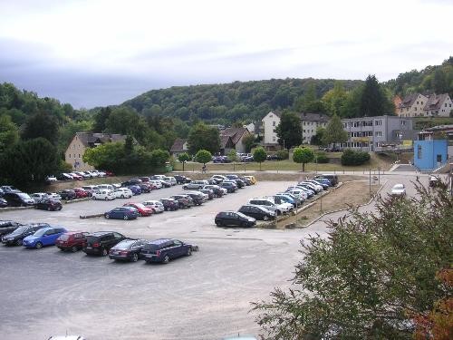 Schotterparkplatz mit parkenden Autos vor dem Kaufland-Gebäude.