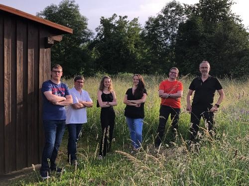 Sechsköpfige Band auf einer Wiese.