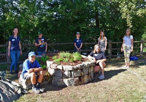 Kinder bauen beim Ferienprogramm eine Kräuterspirale.