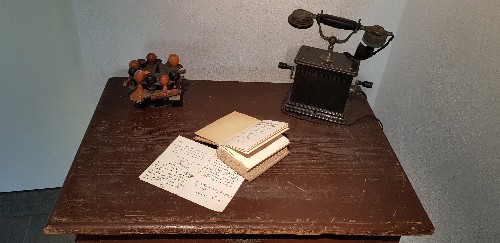 alter Tisch mit alten Stempeln und Telefon, aufgeschlagenes Buch 